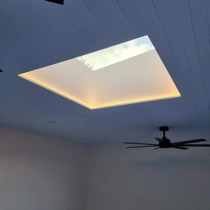 Square architectural skylight framed with concealed warm LED strip lighting in a contemporary home